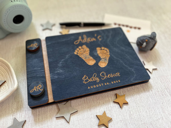 Baby shower guest book with footprints and personalized text on a wooden covers- with a navy wood stain and engraved baby foot prints with personalized text