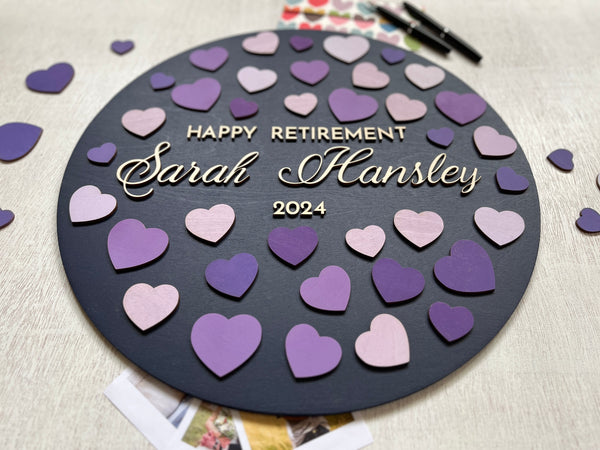 purple hearts on a round board with retiree name to be signed at retirement party