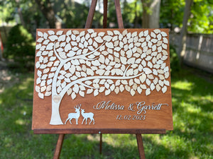 rustic guestbook alternative with deer pair and personalized names on a wooden board with a tree