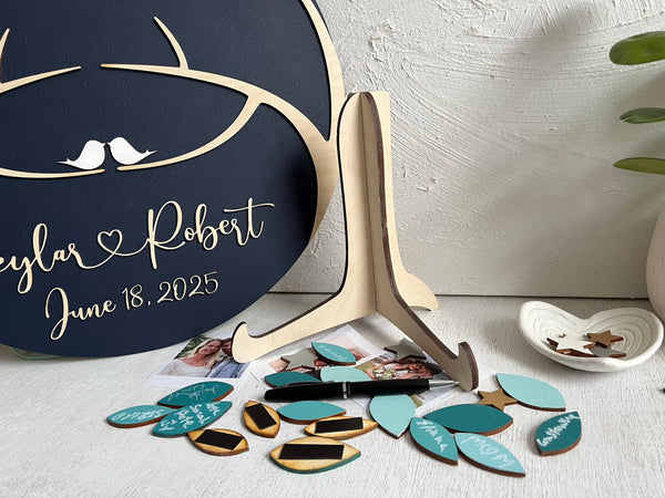 magnetic guest book alternative with leaves for guests to sign and add to the round board that has two trees coming together - leaves in teal personalized