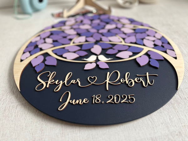 Decorative wedding guest book with purple leaf design and personalized text on a magnetic wooden surafce with removable magnetic leaves in purple, lavender, violet shades. Each guest signs a leaf and the round guest book can be hung in your home as a wedding memento. 