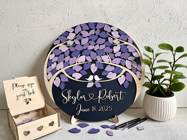 Decorative wedding guest book with purple leaf design and personalized text on a magnetic wooden surafce with removable magnetic leaves in purple, lavender, violet shades. Each guest signs a leaf and the round guest book can be hung in your home as a wedding memento. 