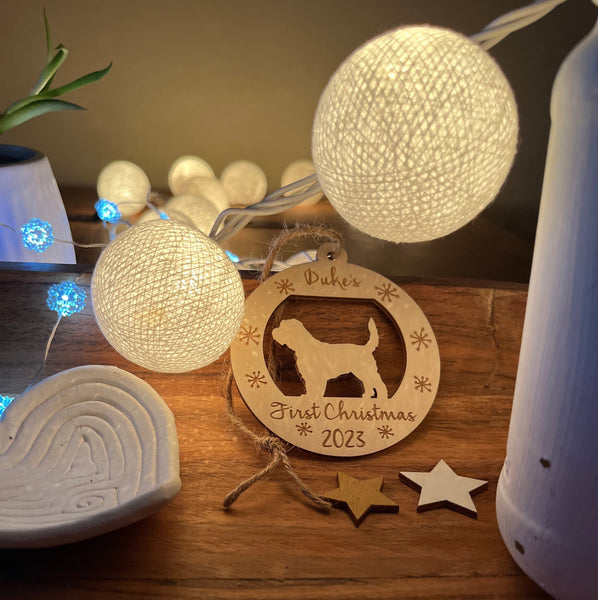 personalized puppy's first Christmas ornament round with golden doodle silhouette shown in a display of Christmas lights