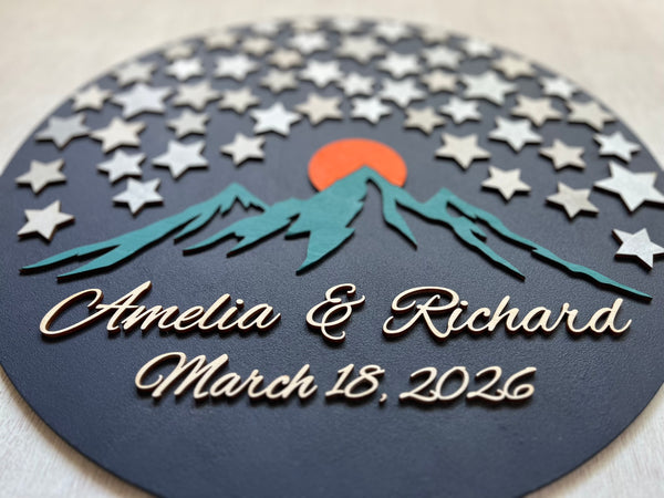 Decorative wedding wood guest book with mountains, stars, and personalized text on a dark background