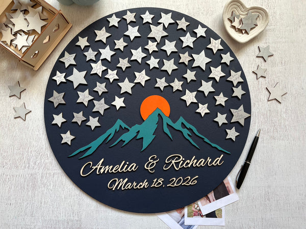Personalized wall art with stars, mountains, and a sunset design on a dark background.Can be used as a wedding guest book alternative for guests to sign a star