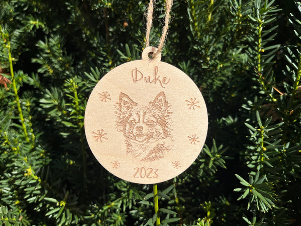 puppy portrait engraved on wood shown on a Christmas tree