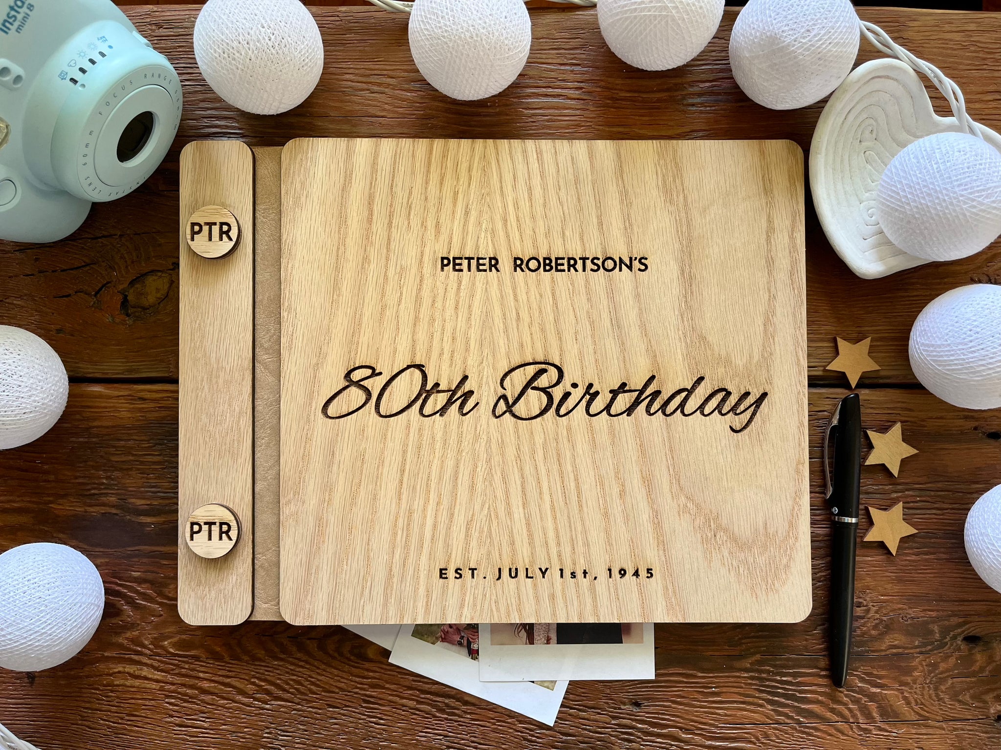 Guest book with wooden engraved covers made for an 80th Birthday celebration and custom engraved buttons for the guestbook