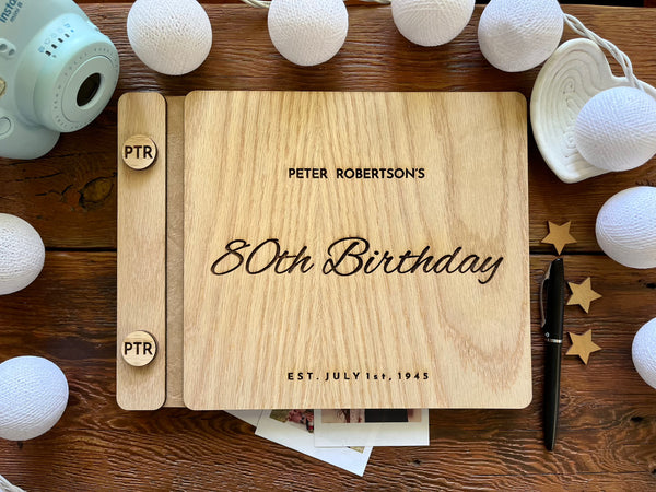 Guest book with wooden engraved covers made for an 80th Birthday celebration and custom engraved buttons for the guestbook
