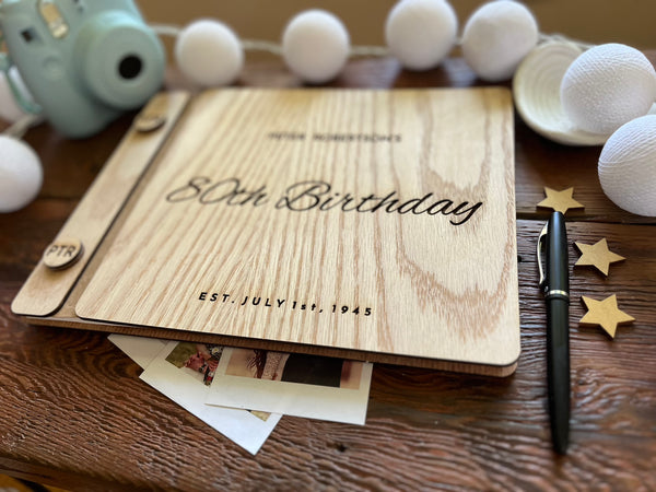 Guest book with wooden engraved covers made for an 80th Birthday celebration and custom engraved buttons for the guestbook