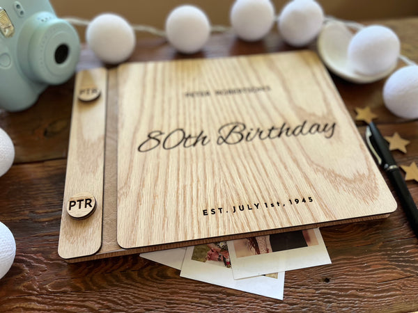 Guest book with wooden engraved covers made for an 80th Birthday celebration and custom engraved buttons for the guestbook