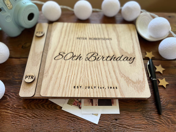 Guest book with wooden engraved covers made for an 80th Birthday celebration and custom engraved buttons for the guestbook