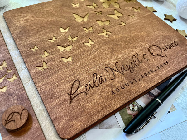Closeup of wooden guest book with engraved text and butterfly design made for a Quince celebration, stained in brown wood stain