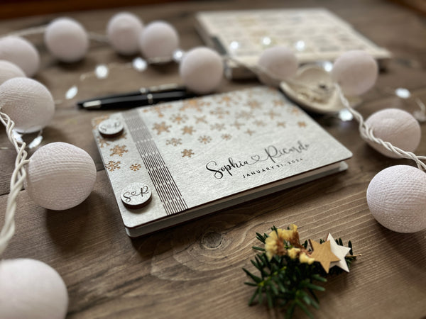 the wedding guest book is made with wood painted in silver and envied with snowflakes for a winter wonderland effect