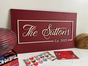 personalized last name sign with established year made on burgundy wood with natural lettering for wedding or office sign. The sign is rectangular and the font is calligraphic. You will personalized your sign with your name, year, color for the background, color for the text as well as font type. 