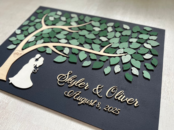 magnetic guest book alternative for wedding made on a rectangular magnetic board with a tree and magnetic leaves for the guests to sign. The board is navy blue and the leaves are in various shades of green and sage green. 