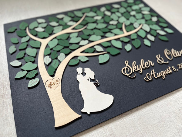 magnetic guest book alternative for wedding made on a rectangular magnetic board with a tree and magnetic leaves for the guests to sign. The board is navy blue and the leaves are in various shades of green and sage green. 