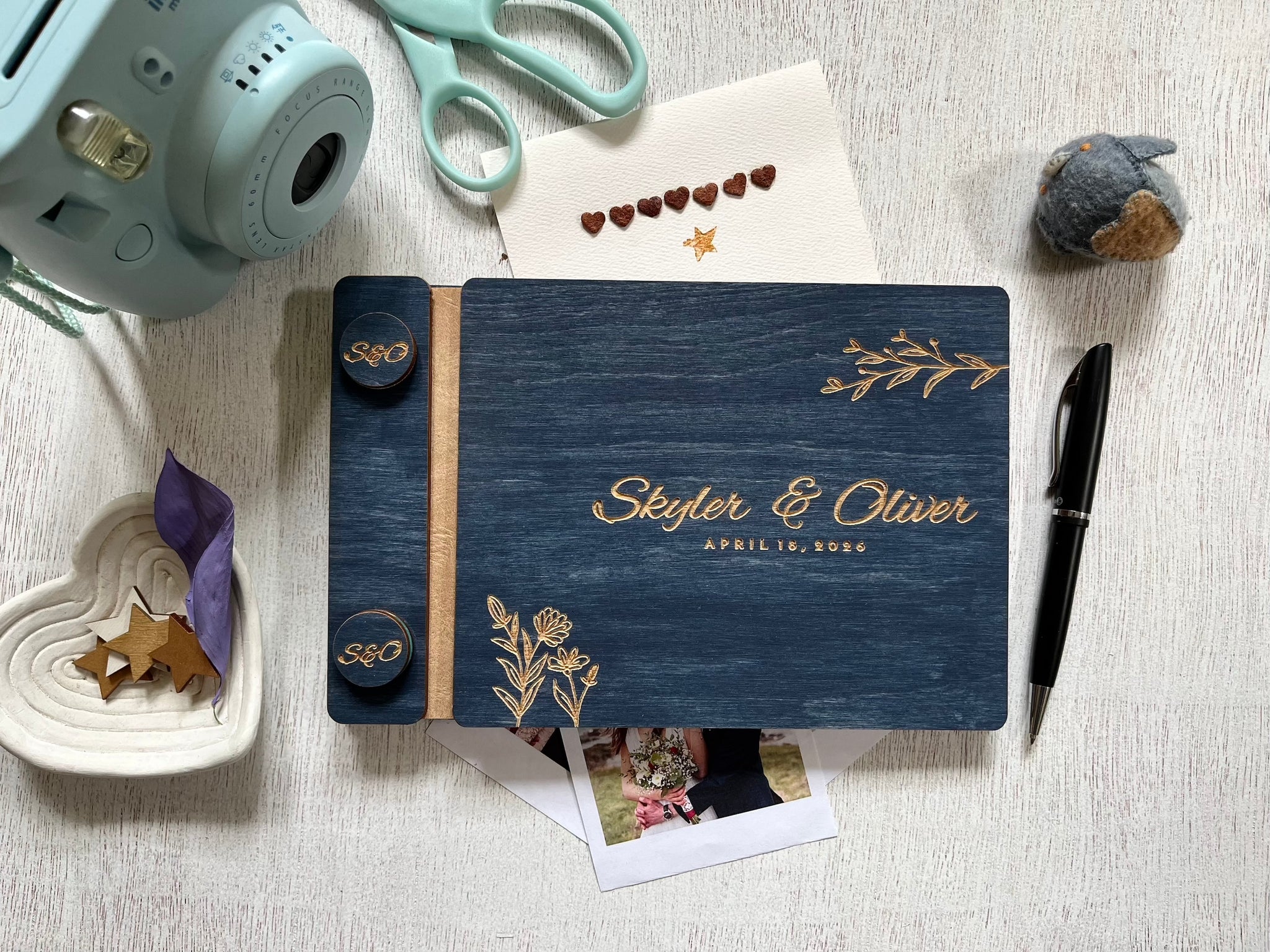 Personalized guest book with decorative floral elements with wooden engraved covers with a navy wood stain. Add your names and wedding or bachelorette party date. Customize the cover colors 
