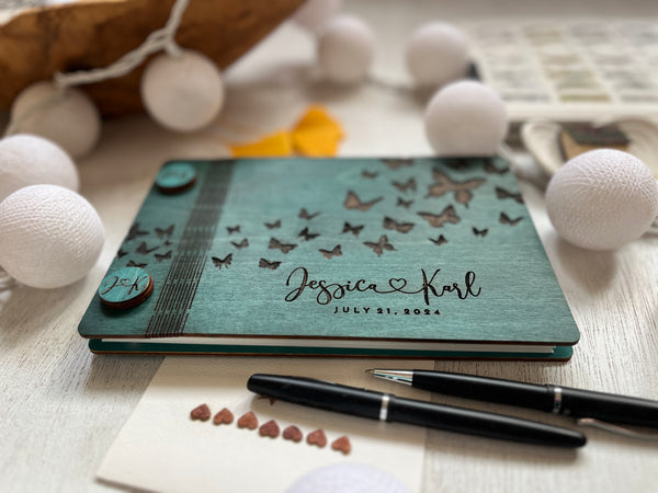 the guest book cover is made in wood engraved with your details and stained in the color of your choice - shown a teal stain