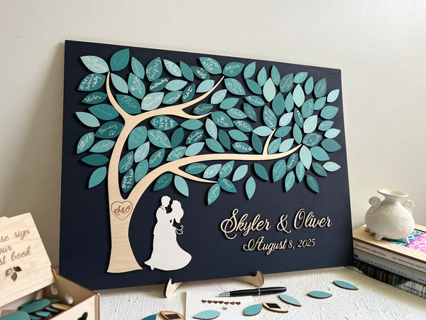 magnetic guest book alternative puzzle made for wedding with personalized names of the bride and groom and wedding date, with magnetic leaves for each guest to sign. The guest book also comes with a holder and an optional box to store the leaves. The top of the box contains the text "Please sign our guest book".