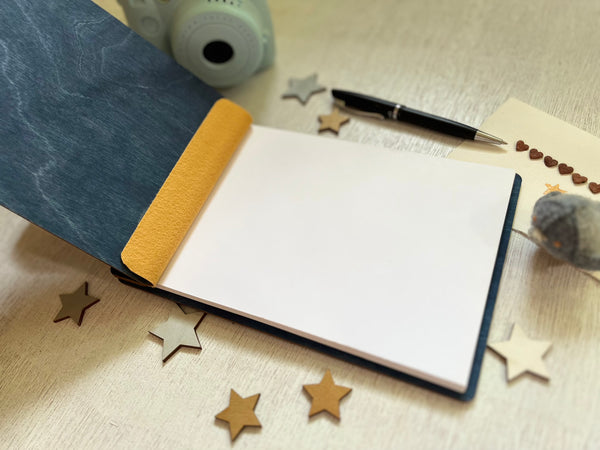 open Baby shower guest book with footprints and personalized text on a wooden covers- with a navy wood stain and engraved baby foot prints with personalized text 