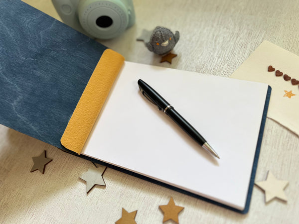 open Baby shower guest book with footprints and personalized text on a wooden covers- with a navy wood stain and engraved baby foot prints with personalized text 