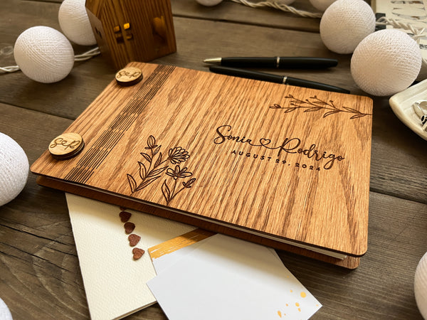 rustic guest book for wishes engraved with the names of the bride and groom and wedding date and ornate floral motifs