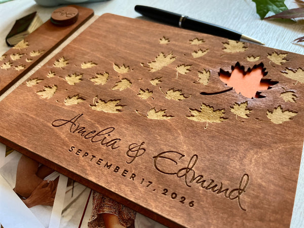 detail of Wooden photo album with maple leaf designs and engraved names, personalized for a fall wedding. 