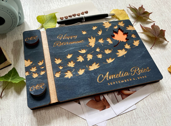 Personalized retirement guest book with autumn leaf design on a custom engraved surface with maple leaves and  personalized with the name of the retiree and the text "Happy Retirement"