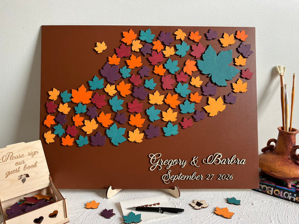 Decorative magnetic guest book with colorful leaf patterns and personalized text on a brown background with maple leaves. Each leaf is magnetic and can be signed and added to the background.
