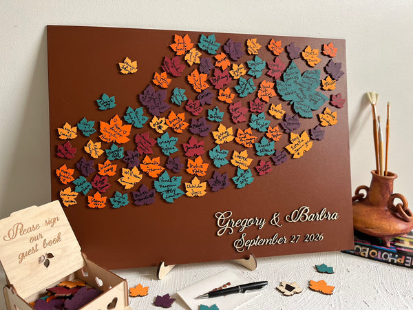 Decorative magnetic guest book with colorful leaf patterns and personalized text on a brown background with maple leaves. Each leaf is magnetic and can be signed and added to the background.