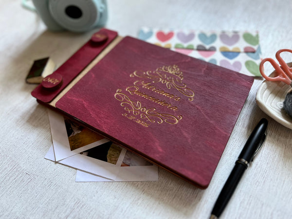 Quinceanera album with engraved text on a burgundy wood surface with a crown and personalized text (name and date)