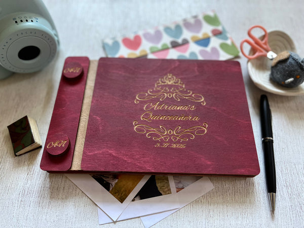 Quinceanera album with engraved text on a burgundy wood surface with a crown and personalized text (name and date)