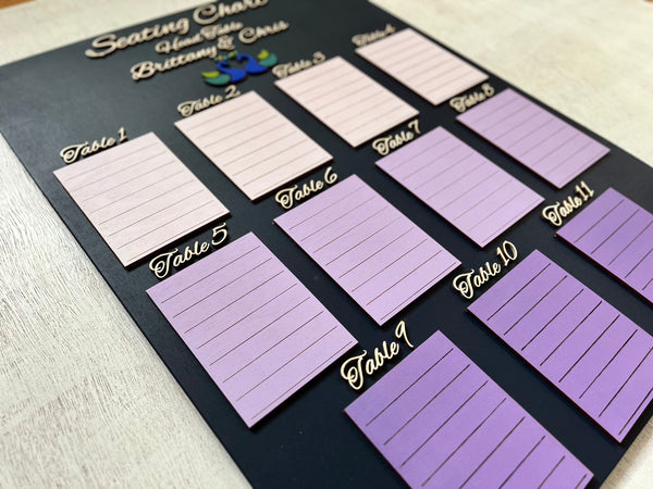 Seating chart with purple and white tiles on a dark navy wooden board with peacocks and cutout lettering