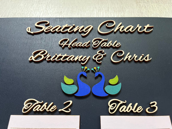 Detail of Seating chart sign with peacock design and text on a dark background