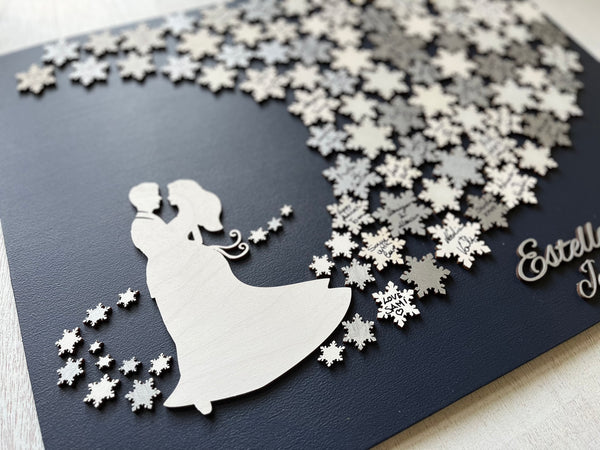 Wedding guest book wall art with snowflakes to sign, personalized names, wedding date and silhouettes of a couple on a navy blue background. 