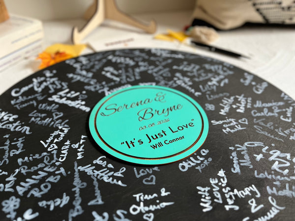 Round decorative round plaque made to look like vinyl record with engraved names on a stand