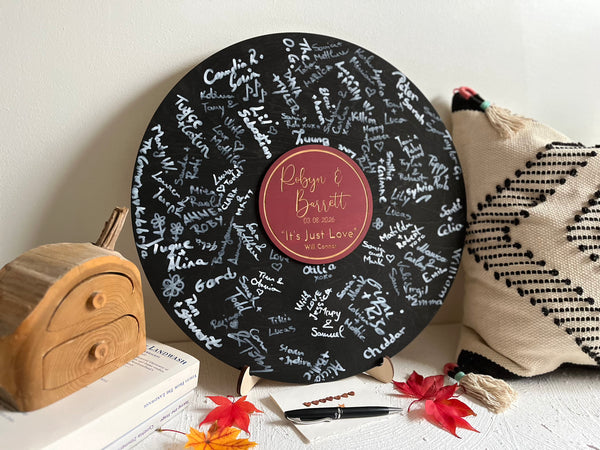 Decorative music record board with signatures and a personalized label with the name of the newlyweds and their favourite song and artist