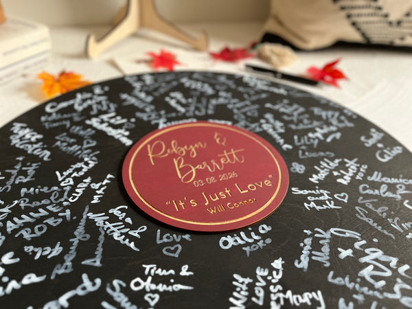 Decorative music record board with signatures and a personalized label with the name of the newlyweds and their favourite song and artist