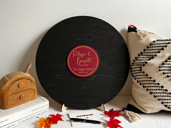 Decorative music record board with signatures and a personalized label with the name of the newlyweds and their favourite song and artist
