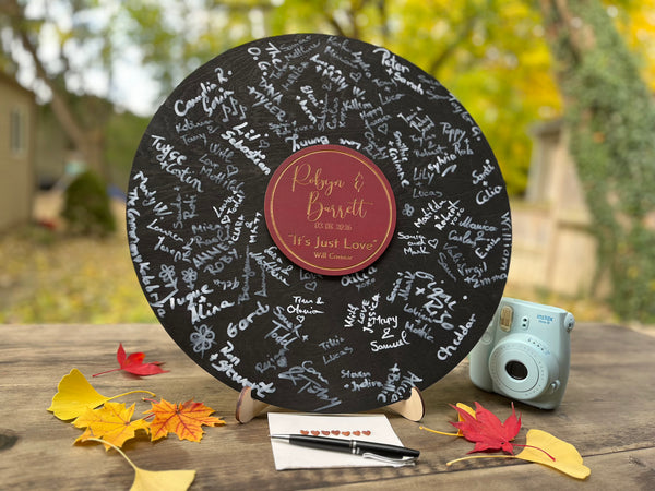 Decorative music record board with signatures and a personalized label with the name of the newlyweds and their favourite song and artist