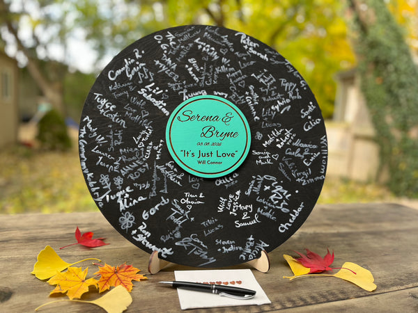 Personalized vinyl record with signatures on a stand outdoors