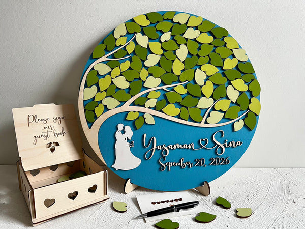 Decorative magnetic wedding sign with tree design and personalized text, accompanied by a wooden guest book box to keep the magnetic leaves