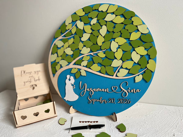 Decorative magnetic wedding sign with tree design and personalized text, accompanied by a wooden guest book box to keep the magnetic leaves