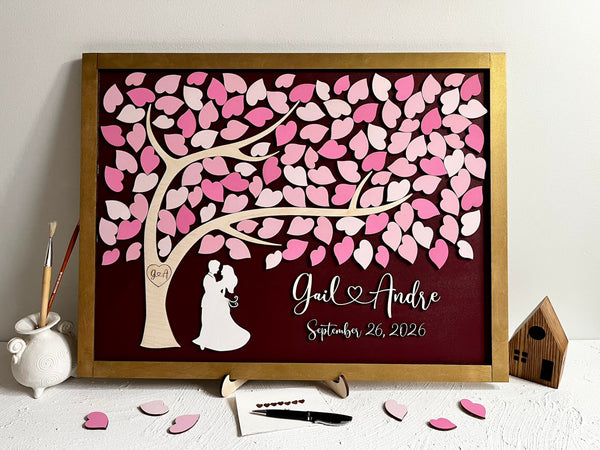 framed guest book with tree of life, pink ;eaves and gold frame with personalized name and wedding date