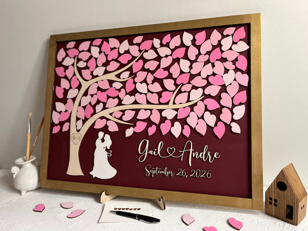 framed guest book with tree of life, pink ;eaves and gold frame with personalized name and wedding date