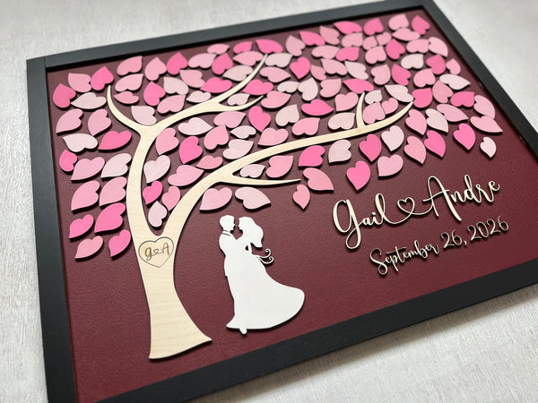 framed guest book with tree of life, pink ;eaves and black frame with personalized name and wedding date
