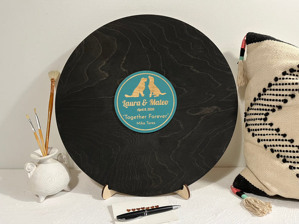 Personalized round black plaque featuring two dogs and personalized text, placed on a stand.