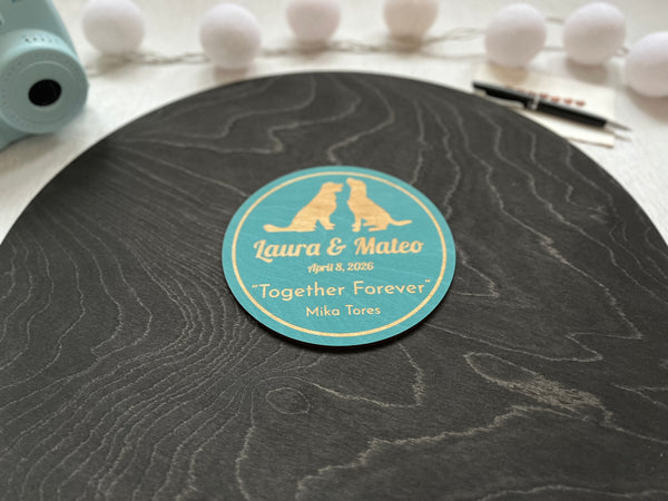 Personalized round black plaque featuring two golden retreiver dogs and personalized text, placed on a stand.