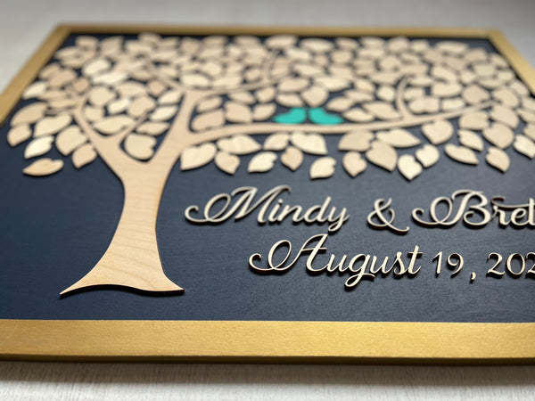 Framed guest book with a tree design, two blue birds, and personalized text on a navy background.