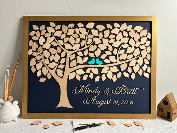 Framed guest book with a tree design, two blue birds, and personalized text on a navy background.